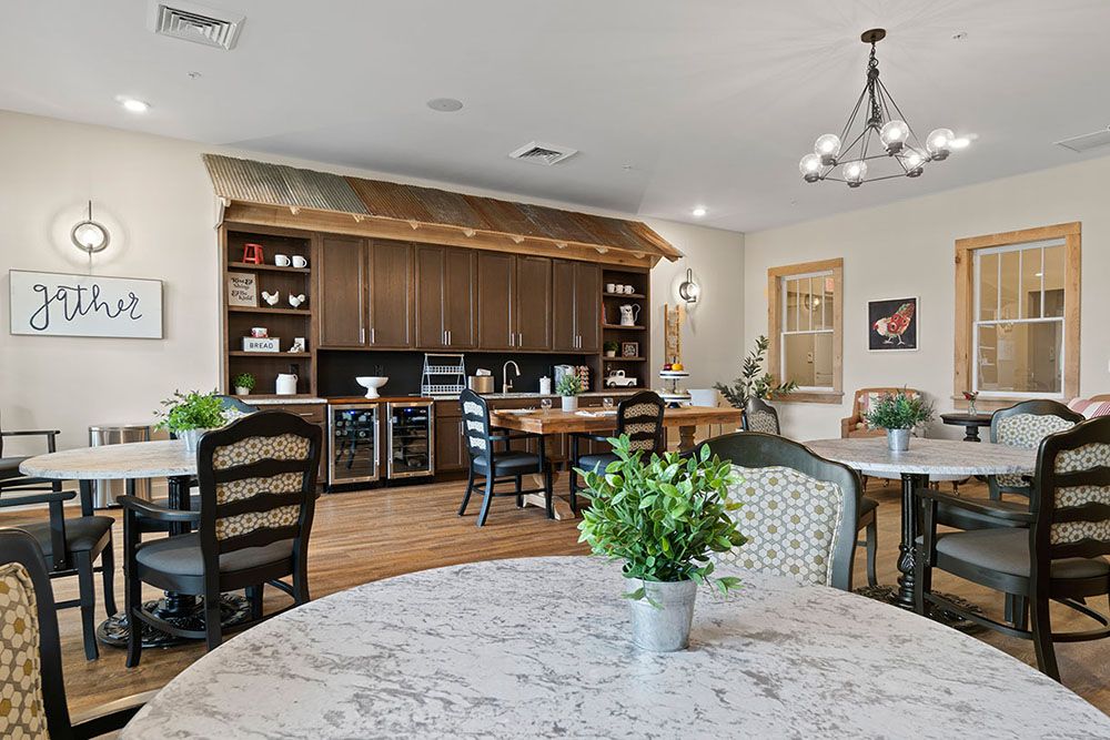 A modern kitchen and dining area featuring wooden cabinets, elegant furniture, and decorative plants.