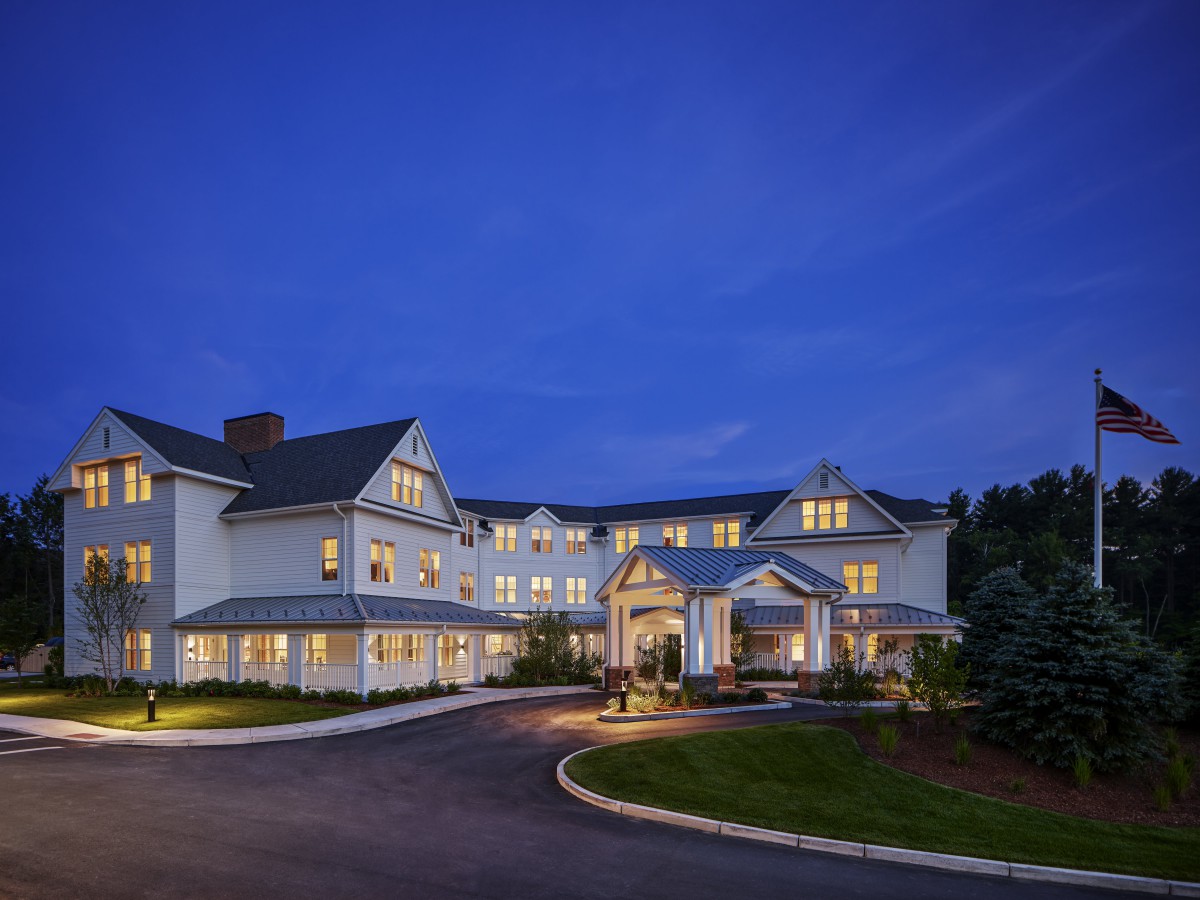 A well-lit hotel building at night with a clear sky.