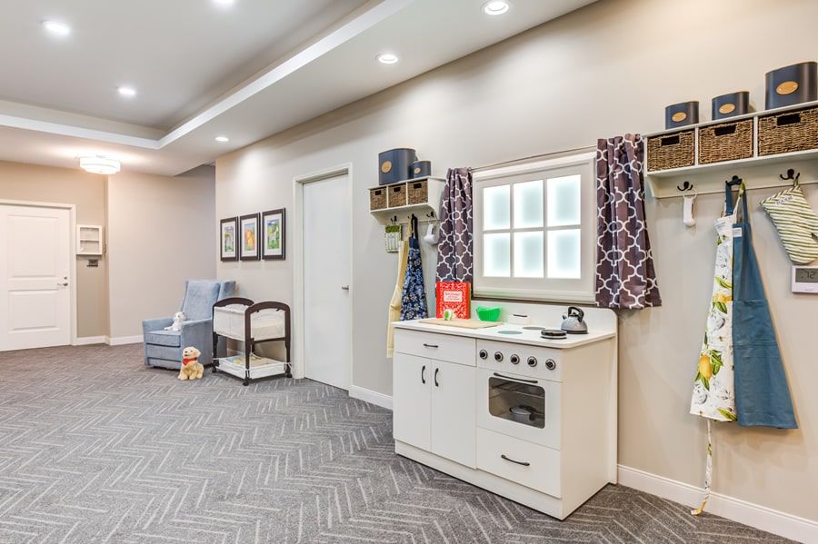 A playful children's room featuring a toy kitchen, cozy seating, and creative decor.
