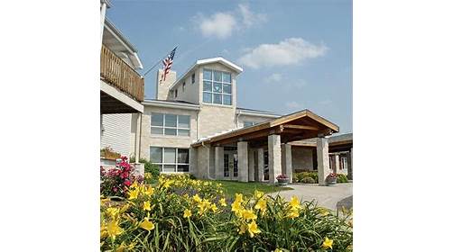 A beautiful residential building surrounded by vibrant flowers and a clear blue sky.