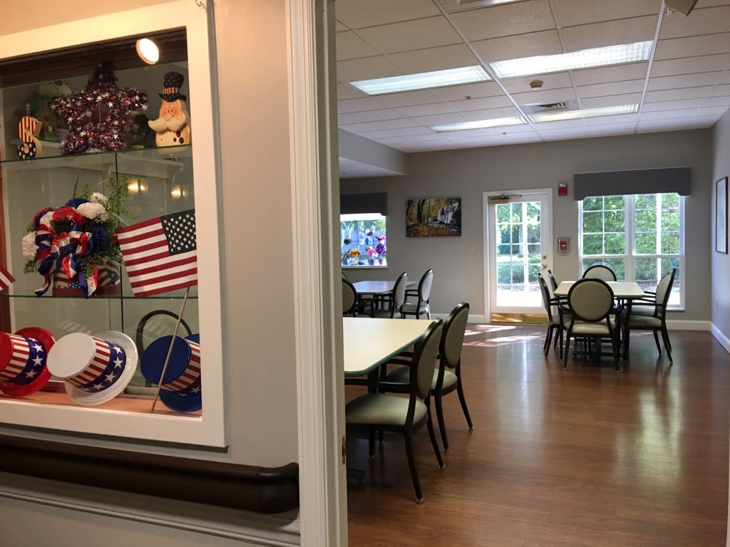 A spacious community room with tables, chairs, and patriotic decorations.