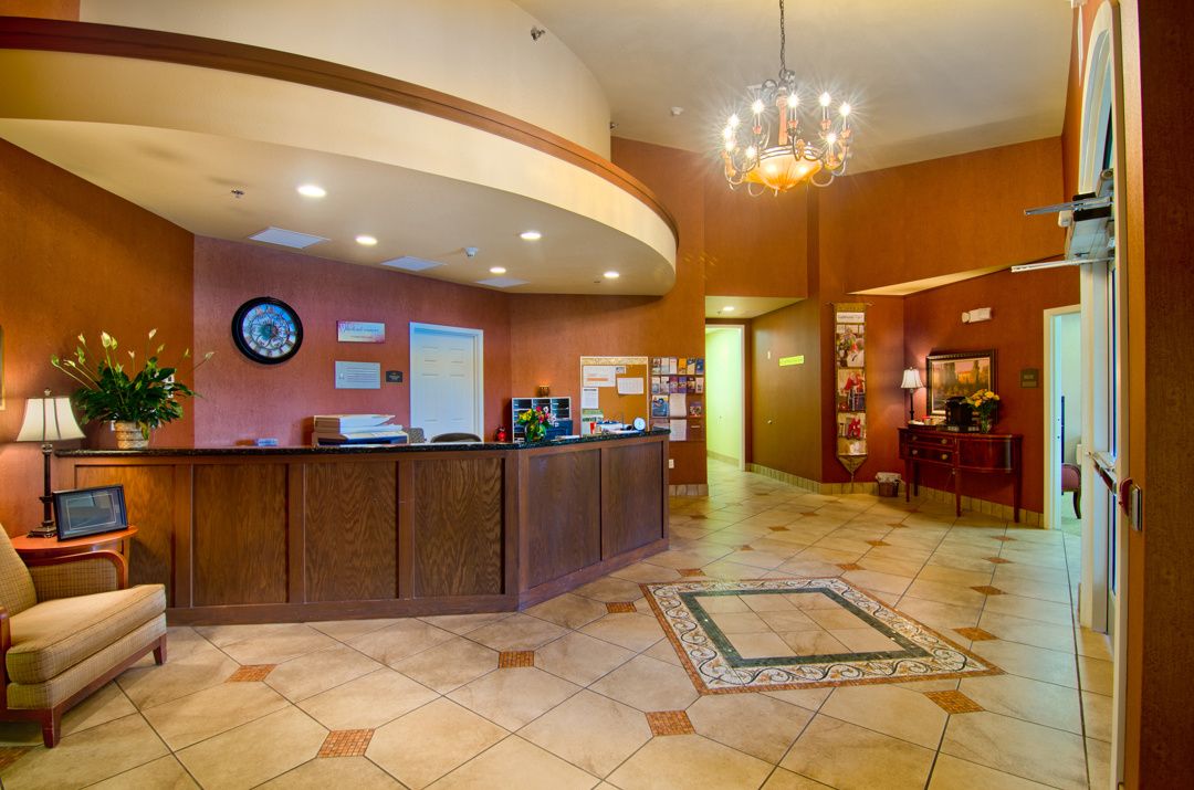 A warmly lit hotel lobby with a reception desk and seating area.