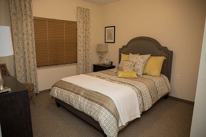 Cozy bedroom interior with neatly arranged bed and decorative pillows.