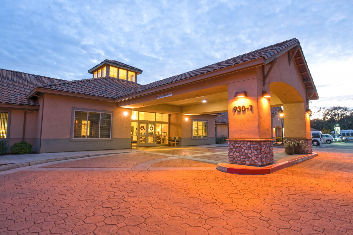 The warmly lit exterior entrance of a hotel during the evening.