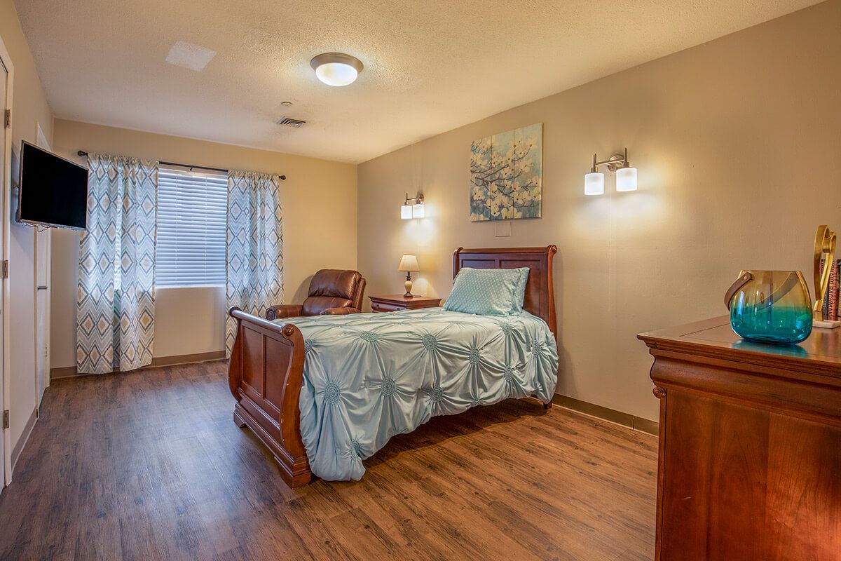 A cozy bedroom with elegant wooden furniture and a neatly made bed.