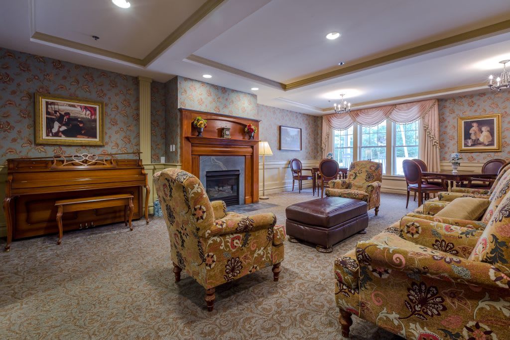A cozy living room with a fireplace, piano, and comfortable seating.
