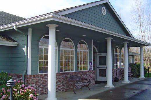 A small building with columns and large arched windows at the entrance.