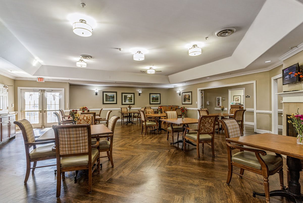 Spacious dining area with wooden floors and elegant lighting.