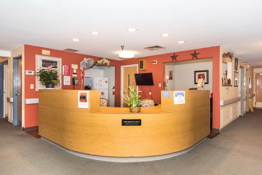 A welcoming reception area featuring a wooden counter and vibrant walls, designed for a comfortable waiting experience.