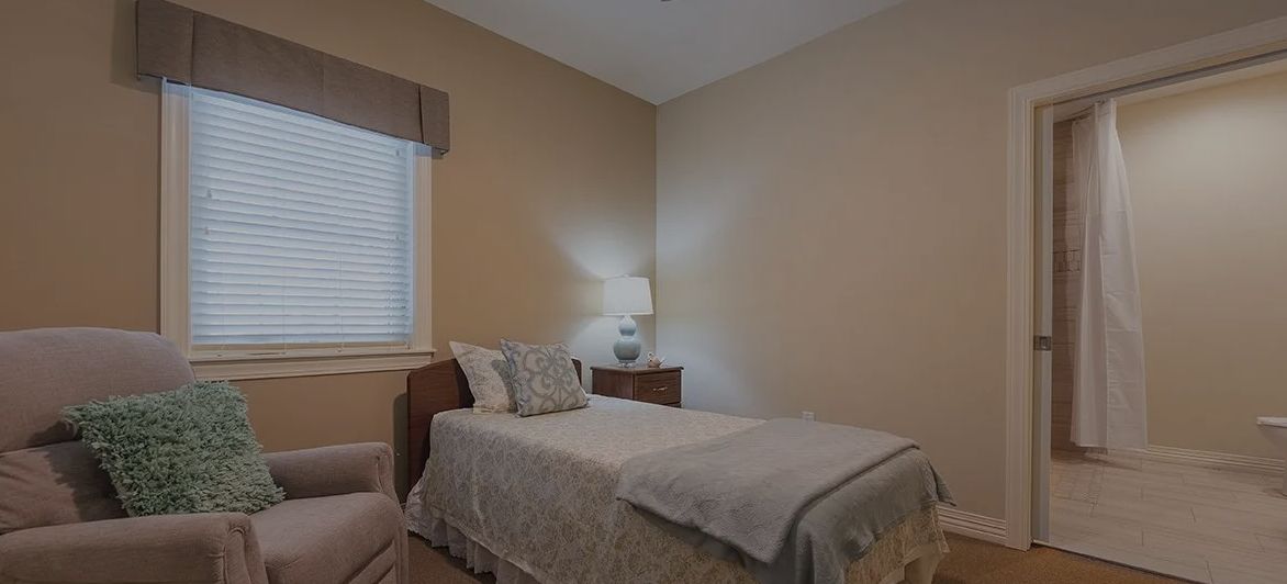 A cozy and neatly arranged bedroom with a single bed, nightstand, and lamp.