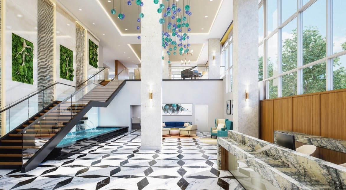 A luxurious hotel lobby featuring a modern design with a marble floor, elegant chandelier, and comfortable seating area.