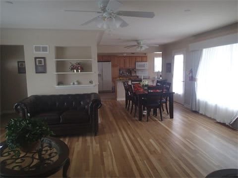 A spacious open-concept living and dining area with wooden flooring and modern furnishings.