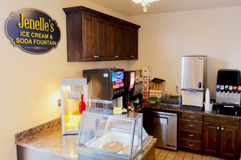 A cozy ice cream shop interior featuring a beverage dispenser and popcorn machine.