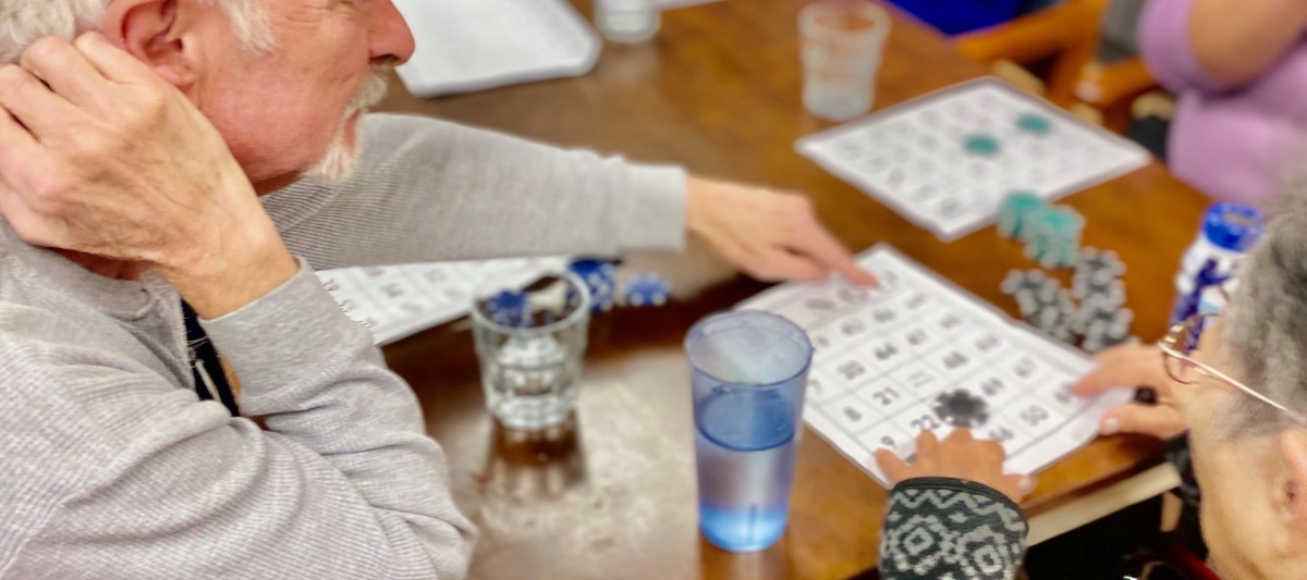 People playing bingo with cards on a table.