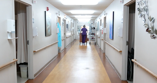 A healthcare professional walking down a hospital corridor.