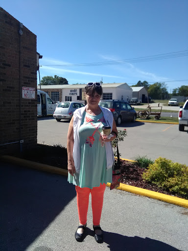A woman enjoying a sunny day outdoors, dressed in a light summer outfit.