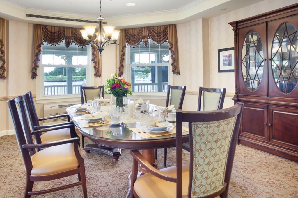 A beautifully set dining table in a well-decorated room with elegant furnishings and natural light streaming through the windows.