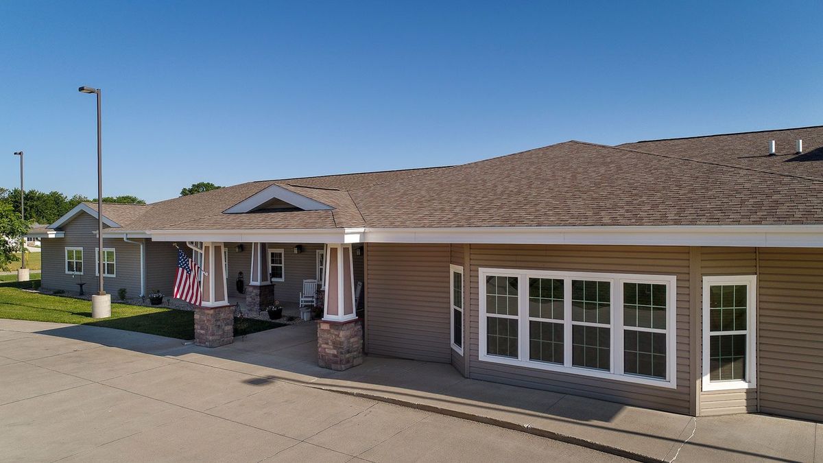 A residential-style building with a porch and an American flag.