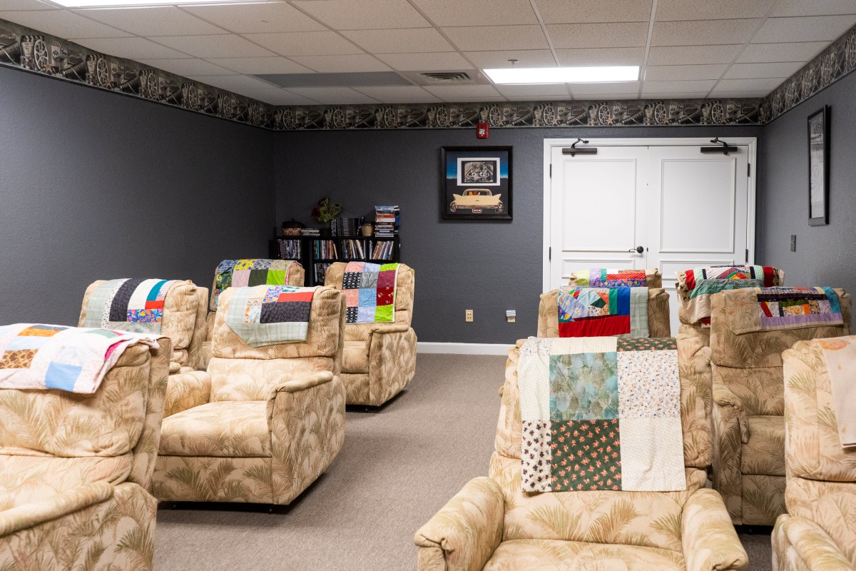 Cozy home theater room with patterned recliners and colorful quilts.