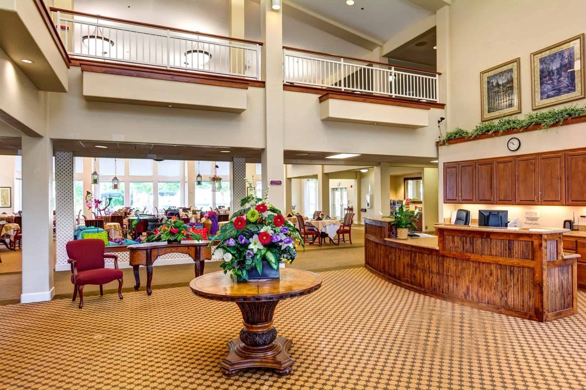 A spacious lobby area with elegant decor, featuring a reception desk and floral arrangement.