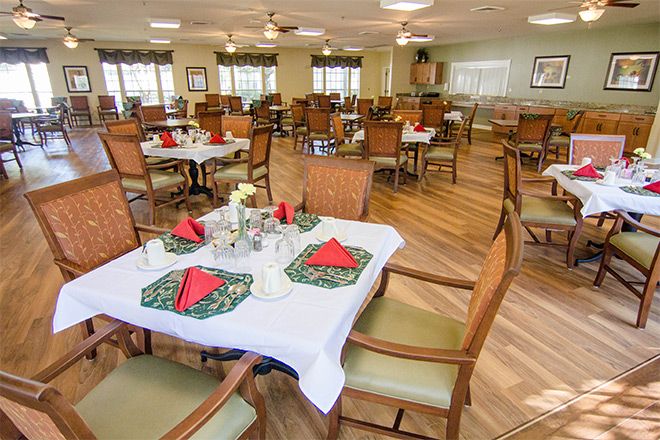 A spacious dining area with neatly arranged tables and chairs, featuring decorative table settings.