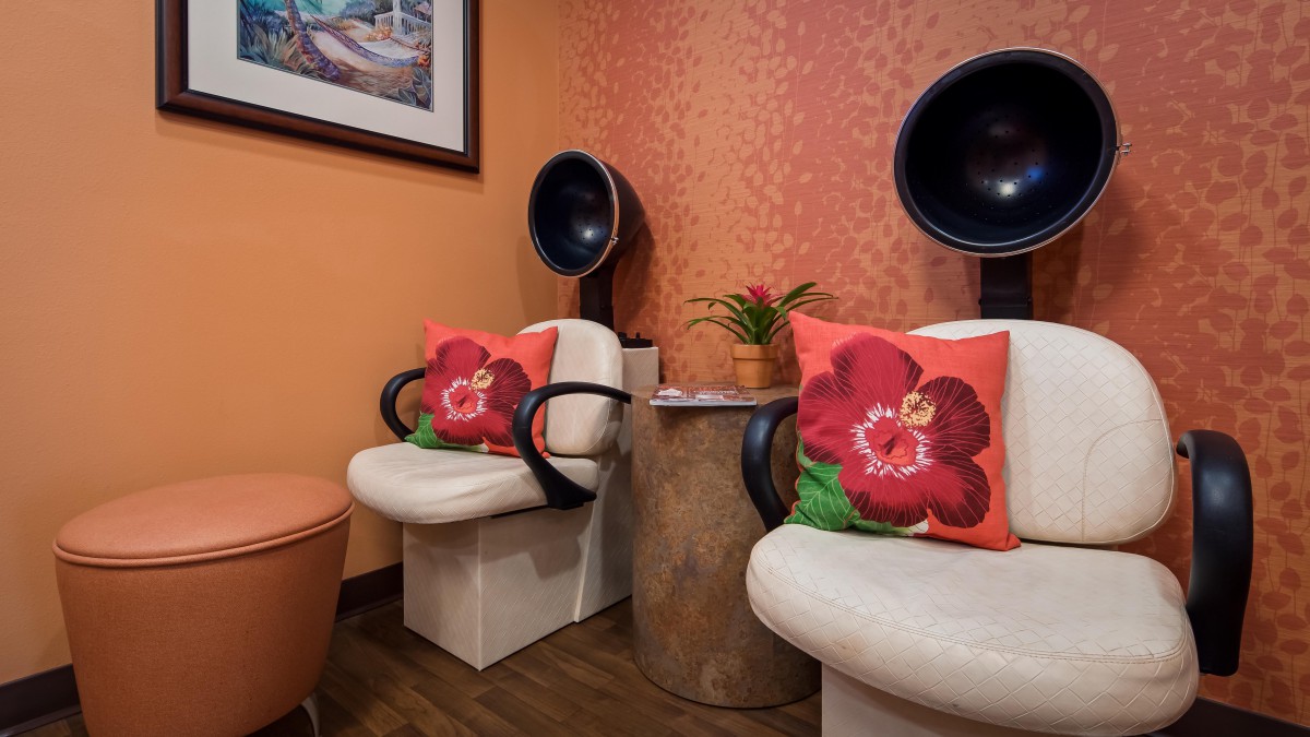 A cozy salon waiting area with floral cushions and hair dryers.