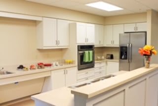 A modern kitchen with white cabinets and stainless steel appliances.