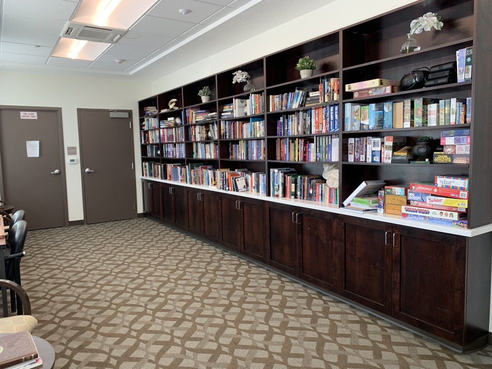 A cozy library corner with shelves filled with books and board games.