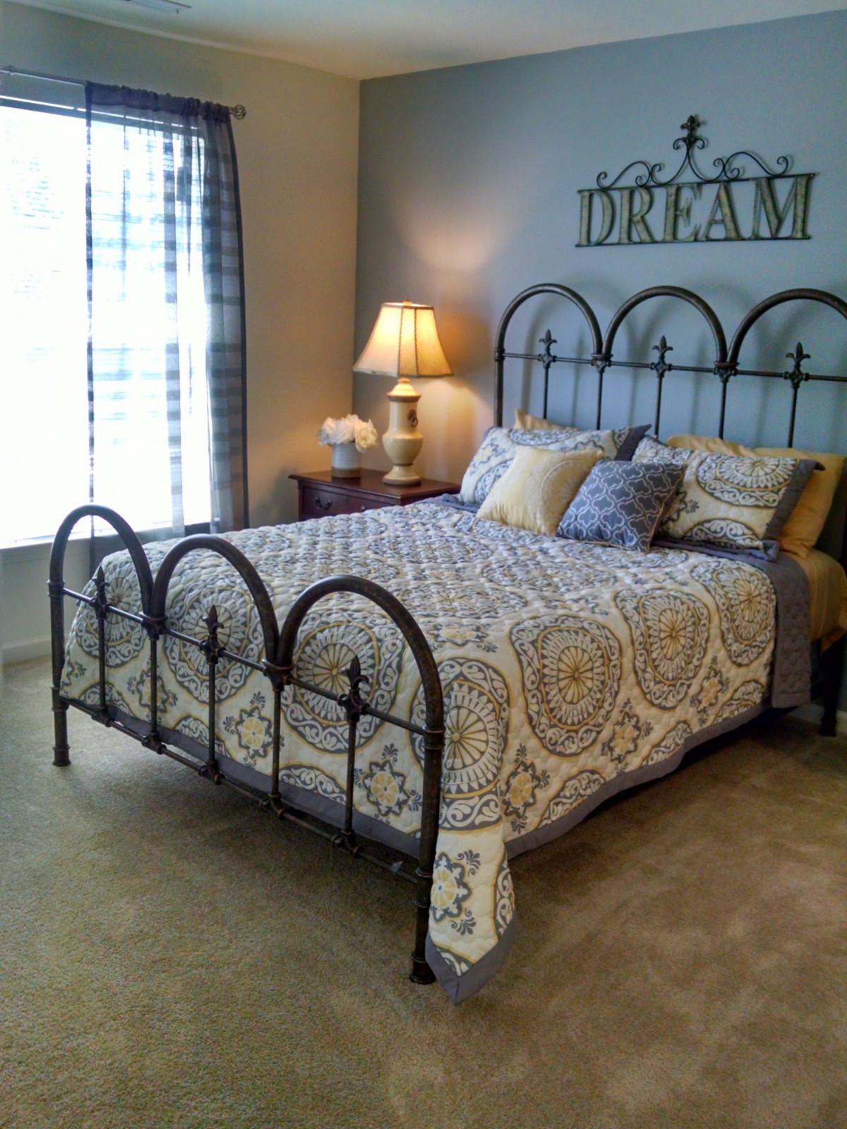 A cozy bedroom with elegant bedding and warm lighting.