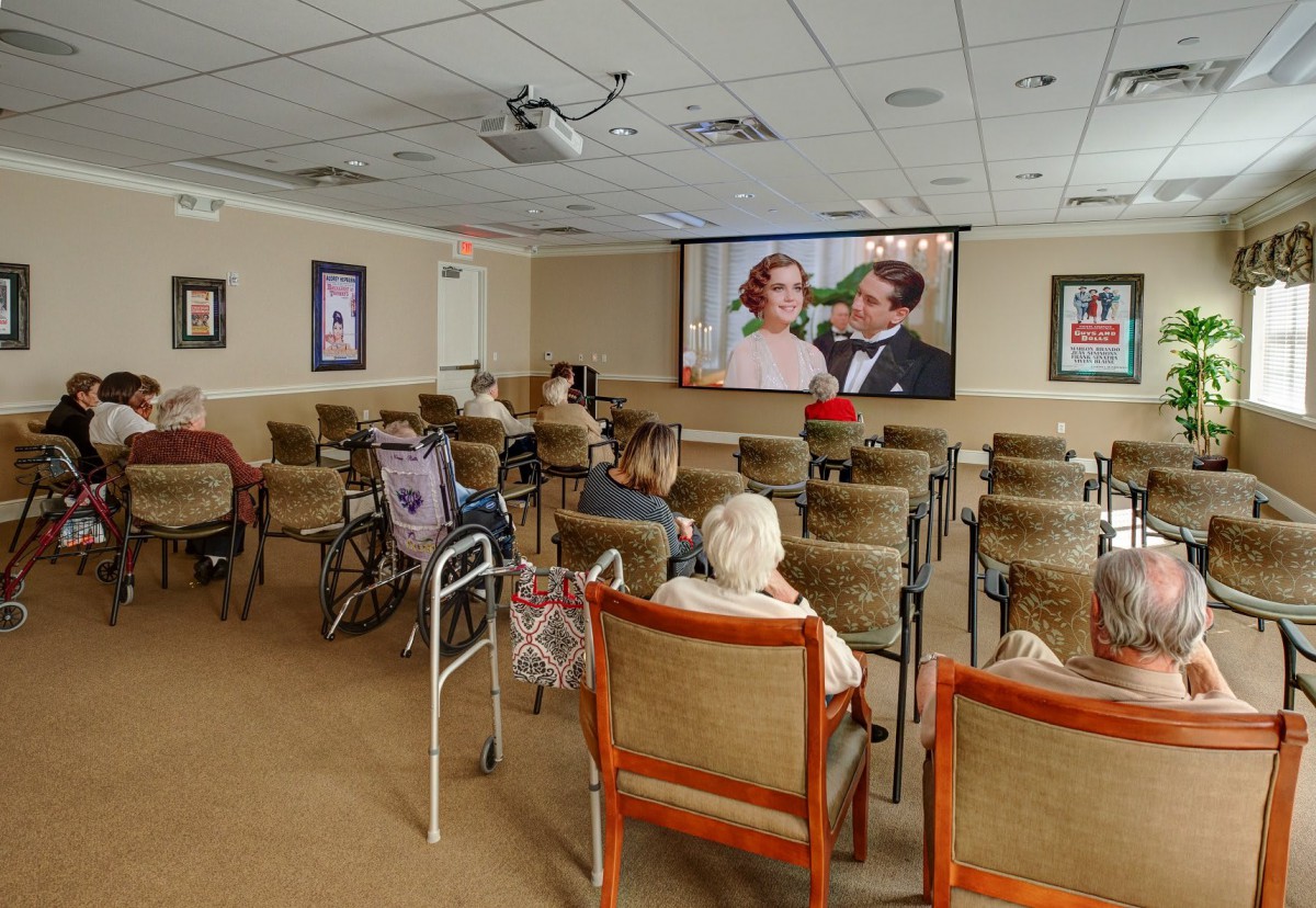 A group of elderly people watching a classic film in a senior center.