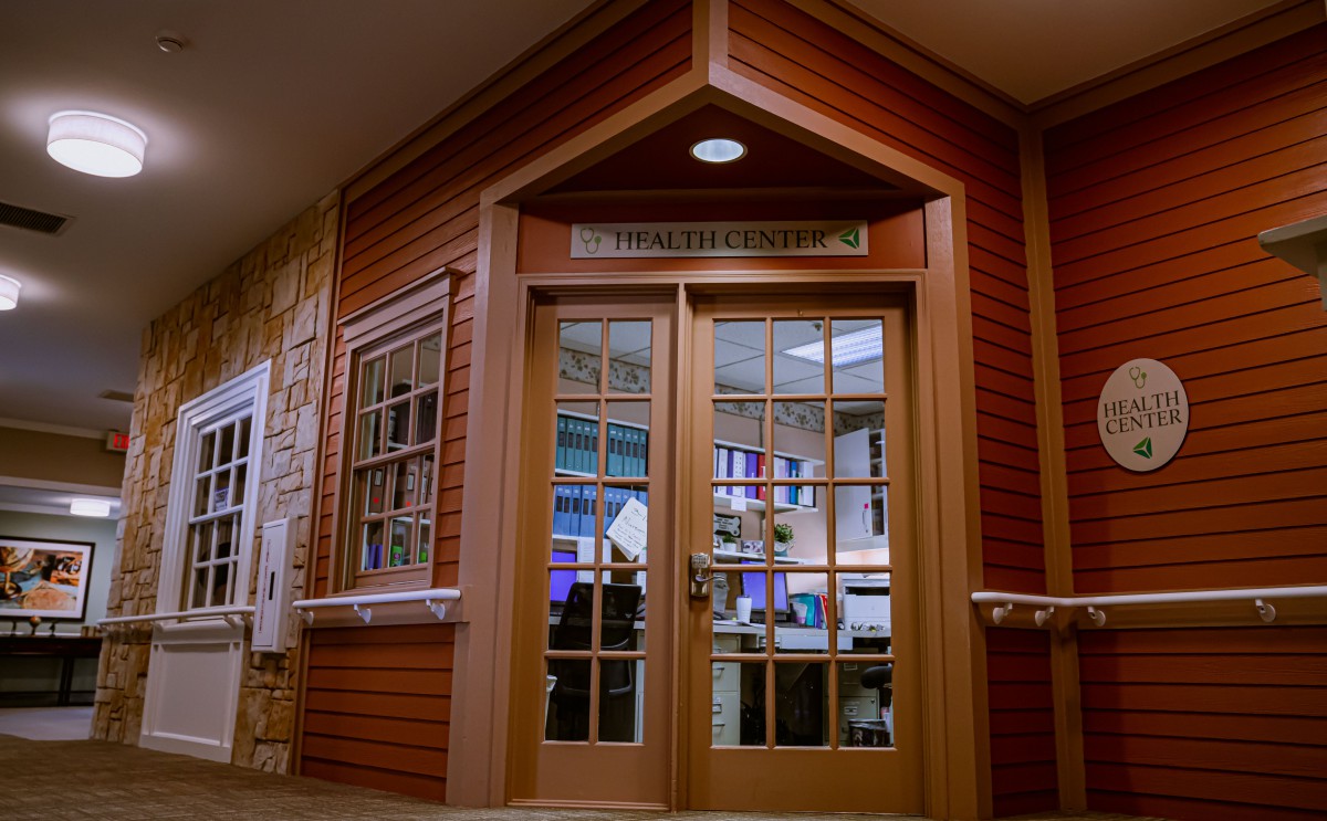 A warmly lit entrance with glass double doors and wood paneling, leading into a building.