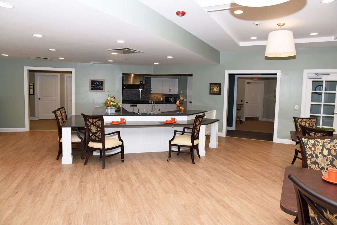 A modern kitchen and dining area with a wide counter and chairs.