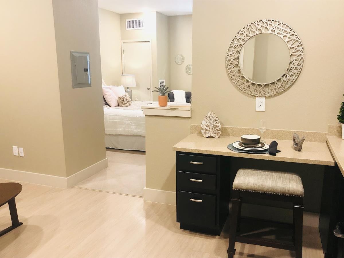 Cozy apartment interior featuring a small desk and adjacent bedroom.