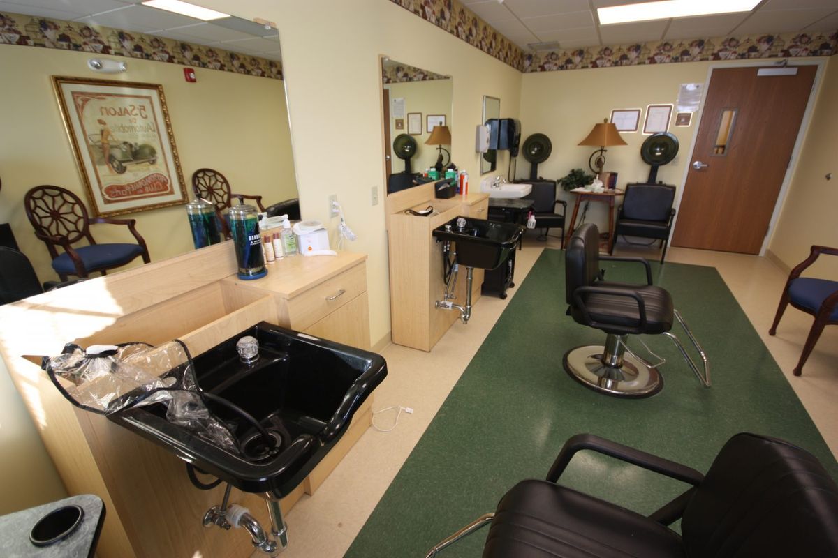 Interior view of a hair salon with chairs, mirrors, and sinks.