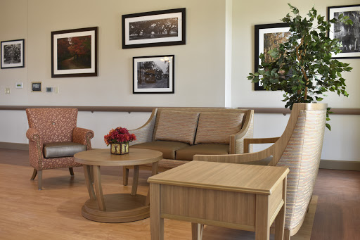 A cozy living room setup featuring comfortable seating, a wooden coffee table, and framed photographs on the wall.