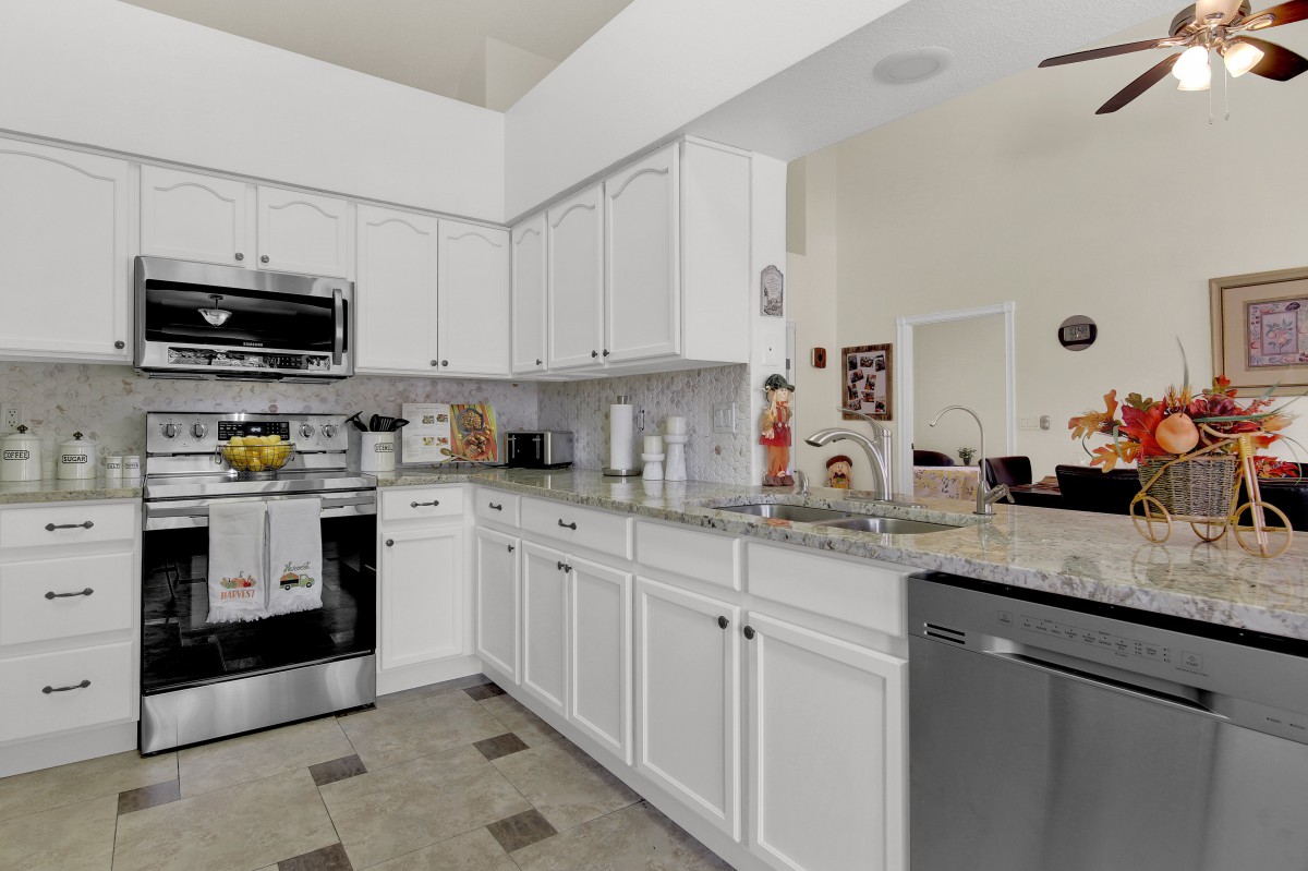 A modern kitchen with white cabinets and stainless steel appliances.