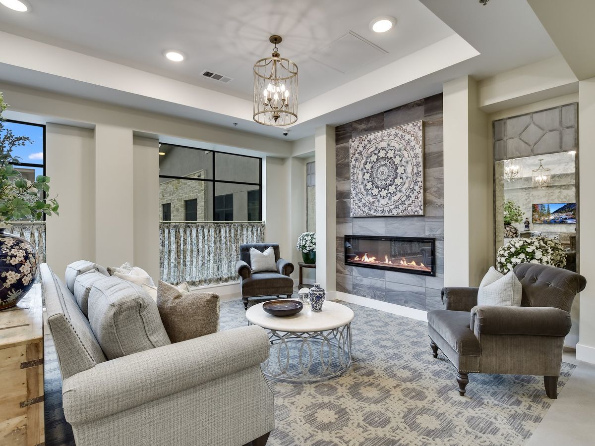A modern living room features a stylish fireplace, comfortable seating, and elegant decor.