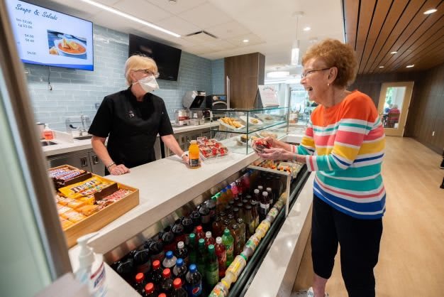 A friendly interaction between a server and a customer at a cafe counter.