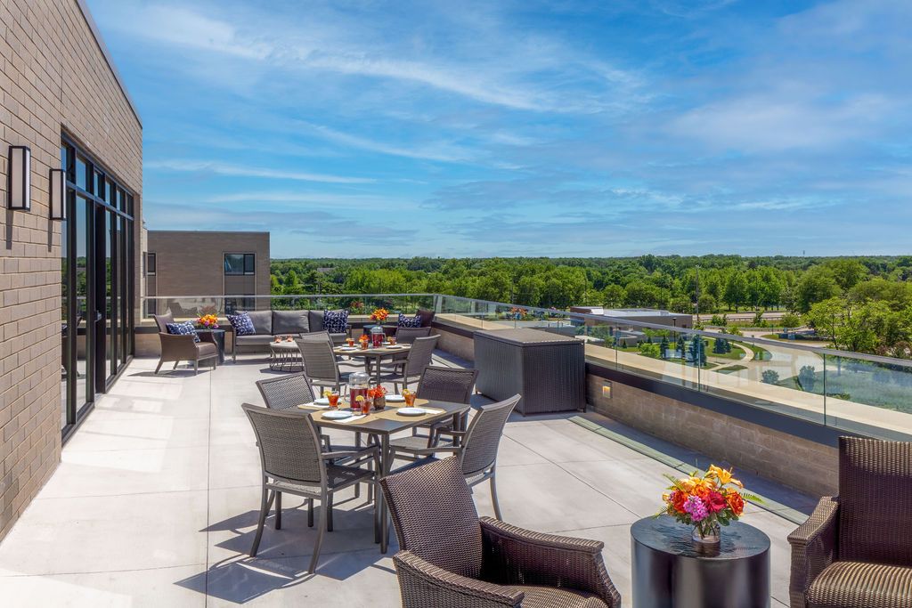 A scenic rooftop patio with tables and chairs under a clear blue sky.