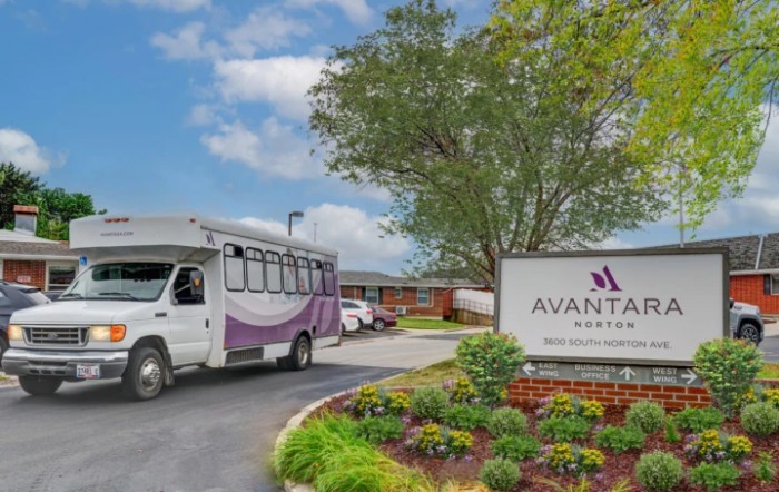 A bus parked in front of a building with a sign reading 'Avante'.
