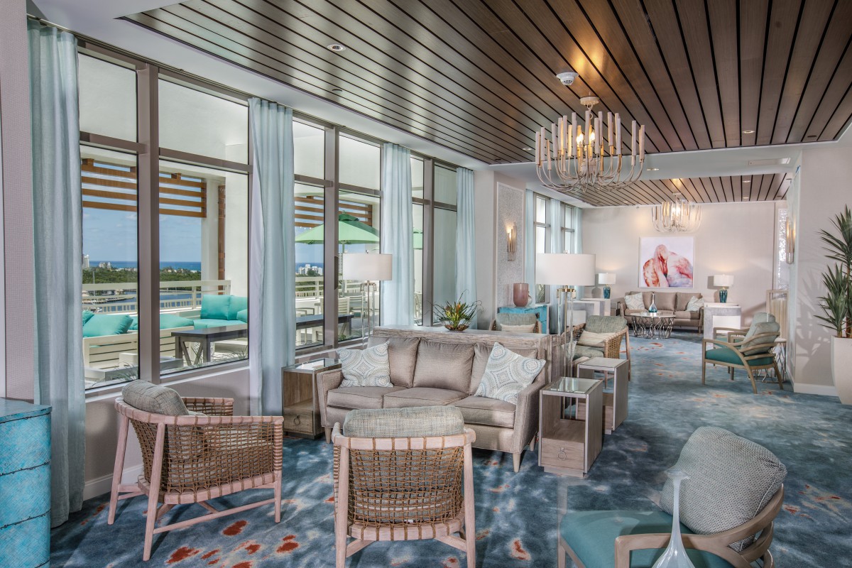A modern living room with stylish furniture, large windows, and a wooden ceiling, offering a warm and inviting atmosphere.