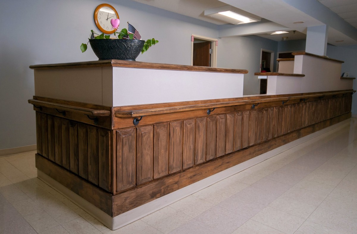 A modern reception area featuring a wooden desk with decorative elements.