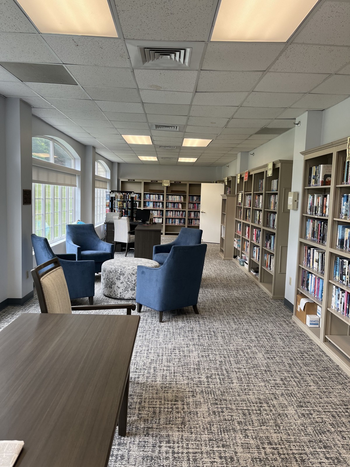 A cozy library with armchairs and bookshelves lining the walls.