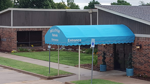 Entrance to a building with a blue awning and clear signage.