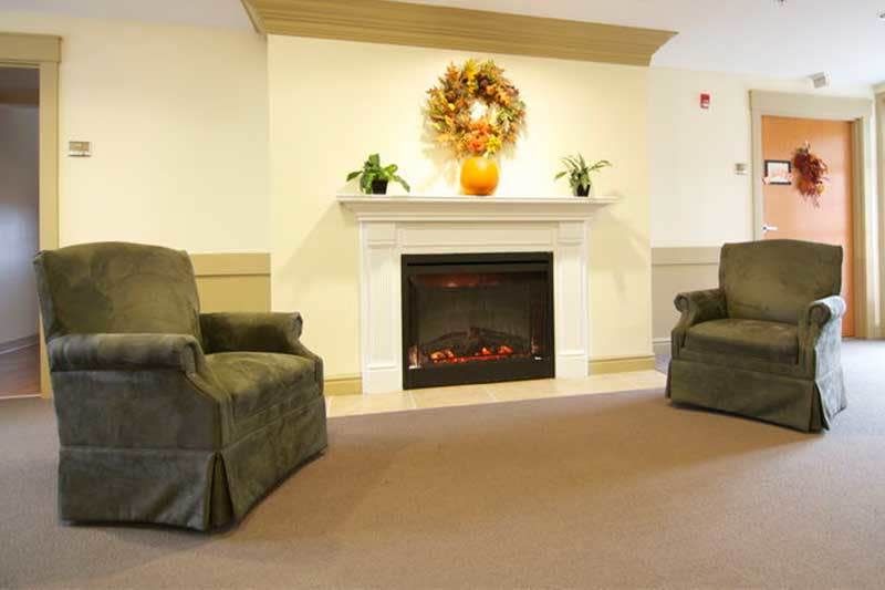 A cozy living room with a fireplace and two armchairs.