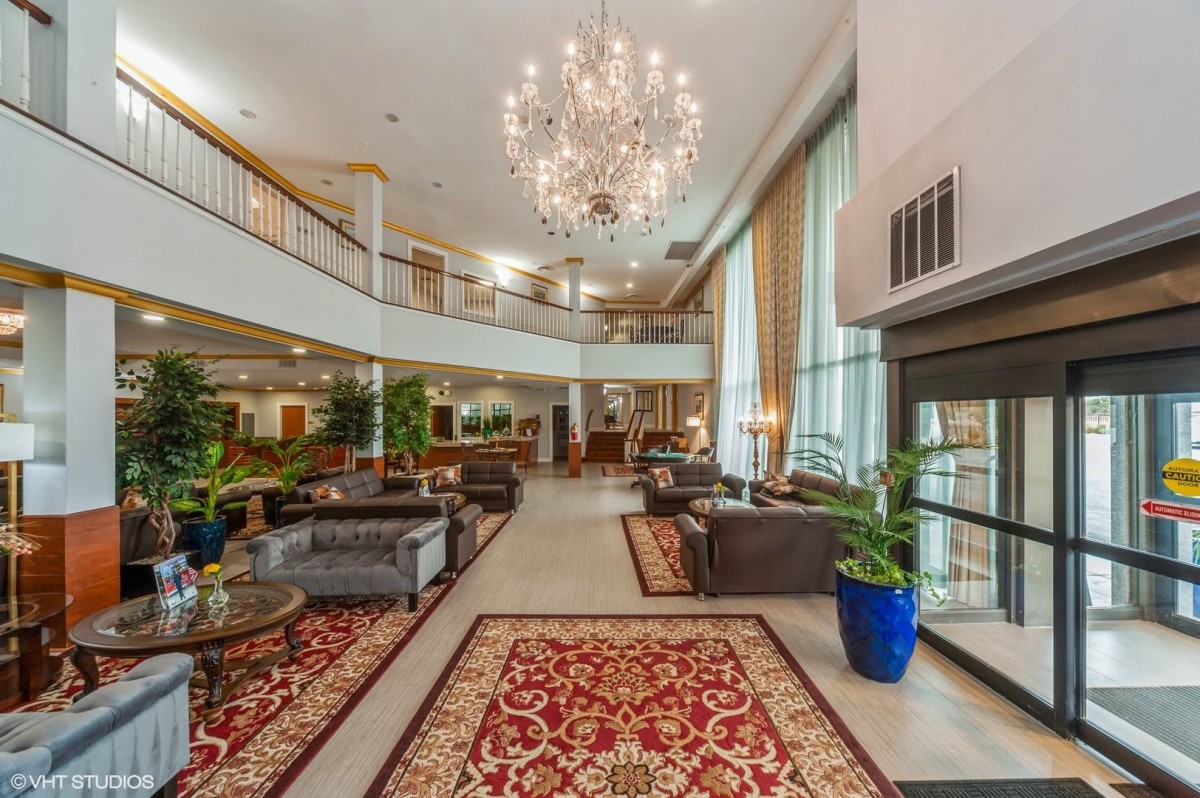 A luxurious hotel lobby featuring elegant chandeliers, sophisticated seating arrangements, and ornate carpets.