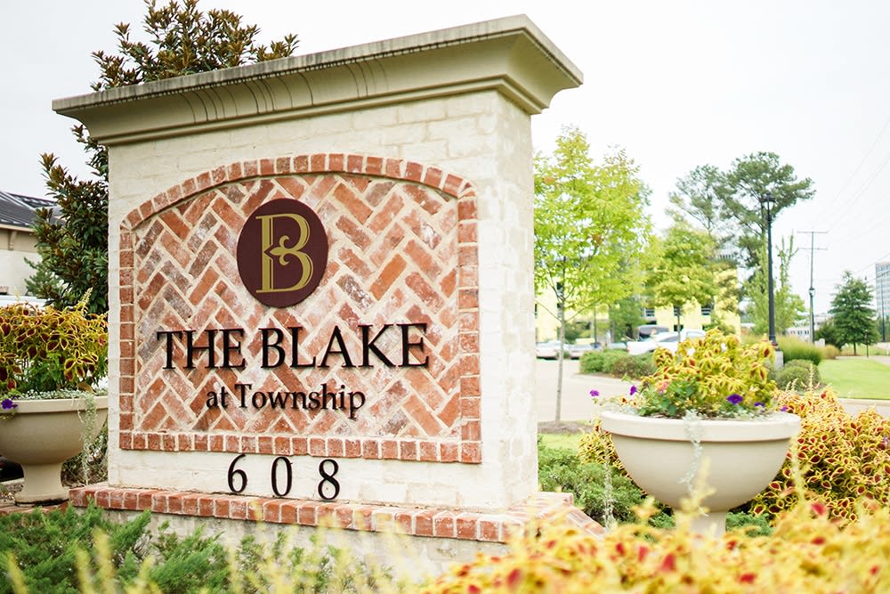 Entrance sign for The Blake at Township surrounded by flowers.
