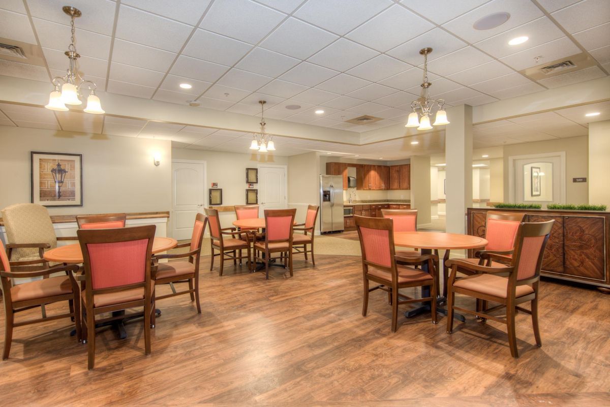 A spacious and well-lit dining area with wooden floors and comfortable seating.