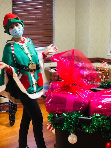 A cheerful Christmas elf posing with beautifully wrapped presents.