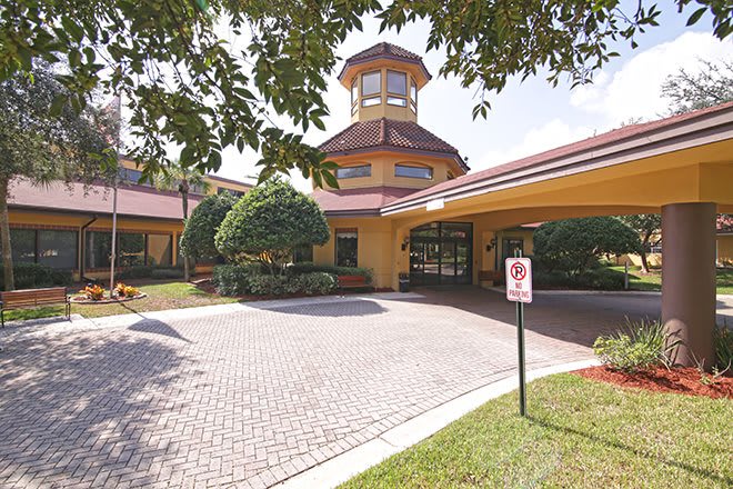 The entrance to a hotel with well-maintained landscaping and a circular driveway.